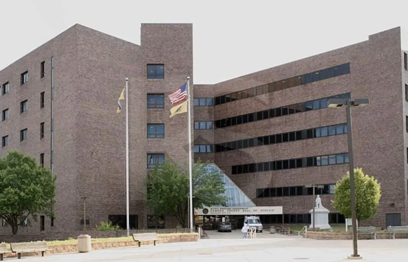 The multi-story brick Camden County Hall of Justice building, often a subject for Camden County Painters, features dark windows and a central glass entrance.